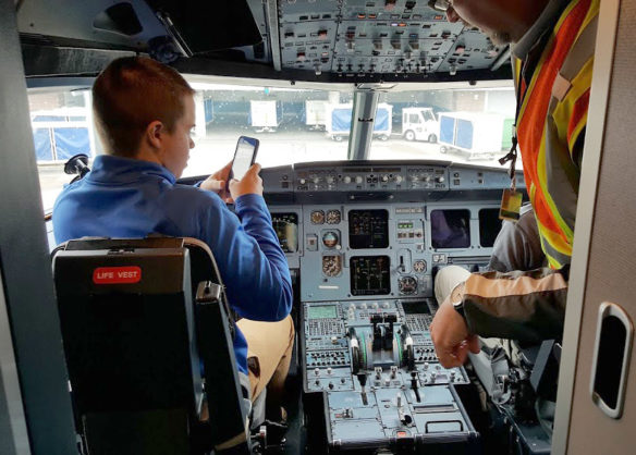 Student "pilot" Nick Wiehoff from Ryle High School (Boone County) checks out the cockpit of the plane in preparation for his internship with Delta Pilot Bob Doyle. Photo by Hallie Hundemer-Booth