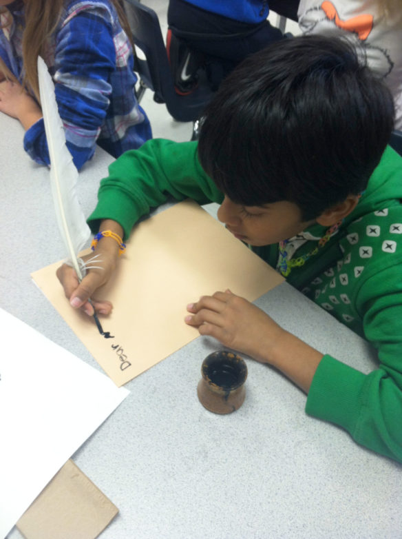 Student at Bridgeport Elementary School (Franklin County) experiment writing with a quill pen and ink as early settlers of Kentucky would have. Photo by Megan Sauter 