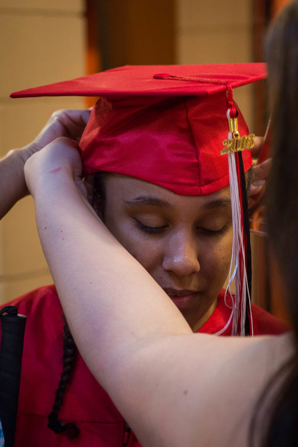 Kinna Waller gets her hat adjusted before the start of the graduation ceremony. Photo by Bobby Ellis, May 25, 2016