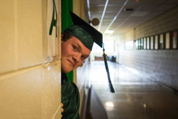 Jeffery Carter peaks out of the boy's locker room before the start of the graduation ceremony at the Kentucky School for the Deaf in Danville. Photo by Bobby Ellis, May 27, 2016