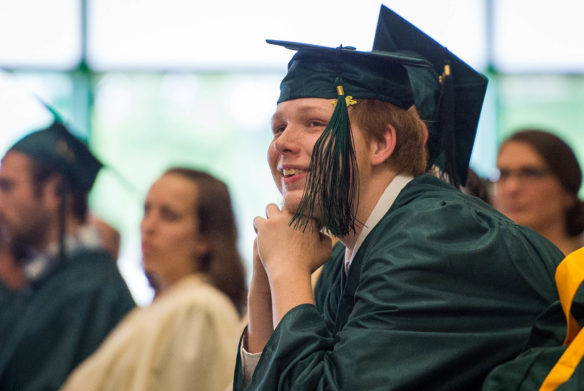 Dallas Deach smiles as he watches a senior video during the Kentucky School for the Deaf graduation ceremony. Photo by Bobby Ellis, May 27, 2016