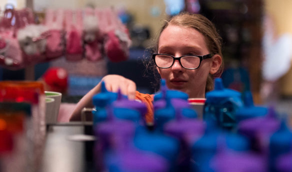 Kentucky School for the Blind senior Tabitha Sutherland arranges souviners in the gift shop of the Angry Birds Ride at Kentucky Kingdom. Sutherland said that she joined the summer work program as a way to get out of the house and add to her resume. Photo by Bobby Ellis, June 24, 2016