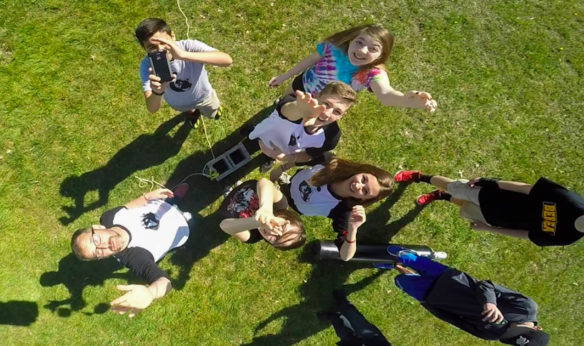 Joshua Woodward, bottom left, a chemistry/physics teacher at Berea Community High School, and his students say goodbye to a high-altitude weather balloon they launched in April. The launch and the balloon, fitted with three cameras, data recorders and a GPS tracker, was a project-based learning experience for his students. Photo courtesy of Joshua Woodward