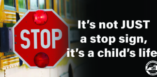This is a picture of a stopped school bus with the stop arm extended. Next to the stop sign reads, "It's not JUST a stop sign, it's a child's life."