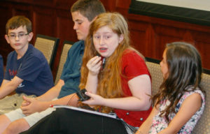 Darby Tassell, a rising freshman at Bowling Green High School (Bowling Green Independent), answers a question during a panel discussion on student agency as Will Hackworth, a rising 5th-grader at W.R. McNeill Elementary School (Bowling Green Independent), Parker Stoubaugh, a rising freshman at South Warren High School (Warren County) and Gracie Learner, a rising 4th-grader at Kyrock Elementary School (Edmonson County) listen. Photo by Mike Marsee, June 24, 2016