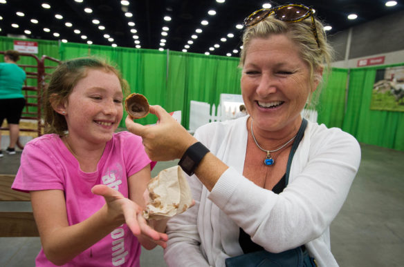 Sarah Hunt, right, holds a melting ice cream cone Heather Houseman as the two take a break during the State Fair. Photo by Bobby Ellis, Aug. 18, 2016