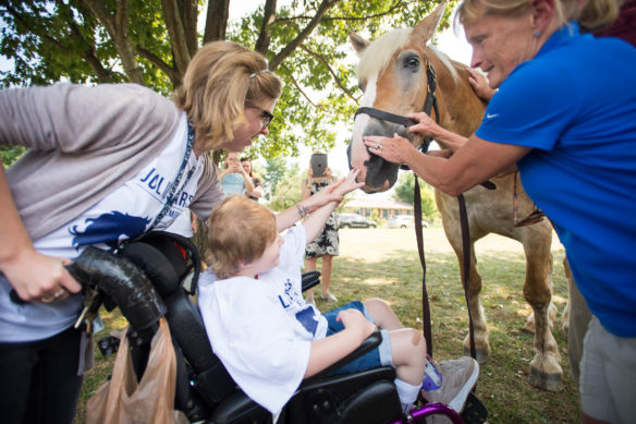 Helen Weber, a special ed. student at Julius Marks Elementary (Fayette), pets Mercy, a rescured Belgian draft horse, who serves as the spokesmodel for Take the Reins. Take the Reins serves to introduce students to different job opportunities inside the equine industry.  Photo by Bobby Ellis, Aug. 29, 2016