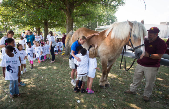 Students from Julius Marks Elementary (Fayette) are helped by Karen Gustin as they pet Mercy, a rescued Beligan draft horse as she visited the school. Photo by Bobby Ellis, Aug. 29, 2016