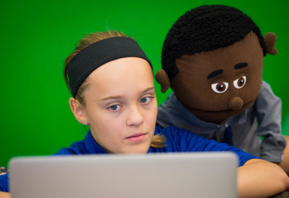 Cloe Stivers has a puppet look over her shoulder as she reviews footage from her groups video assignment. Photo by Bobby Ellis, Sept. 15, 2016