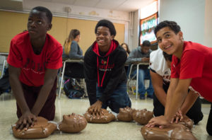 James Mambu, left, Josh Eddings and Zander Makon pracitce hands-only CPR on dummies during a class put on by Start the Heart Foundation at Fern Creek High School (Jefferson County). Photo by Bobby Ellis, Sept. 23, 2016