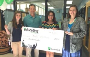 Rachel Matthews, right, a gifted and talented teacher at Maxwell Spanish Immersion Magnet Elementary School (Fayette County), is presented with a $1,000 check by Bethany Denning, second from right, of Lexmark International Inc., which gave Matthews its first Educating Excellence Award of the 2016-17 school year. Student Caroline Blitch, left, and her father, Robert Blitch, represent the school at the presentation. Photo courtesy of Lexmark