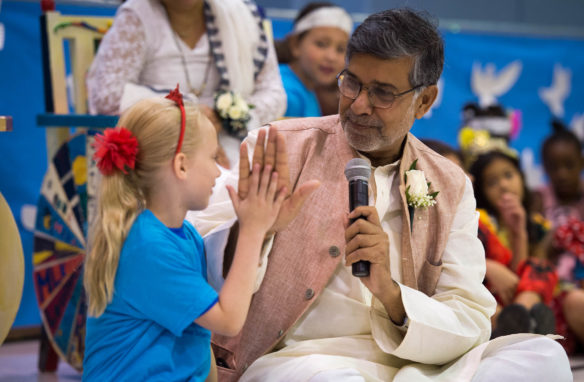 Rosie Kate, a 2nd grader, gives a high-five to Kailash Satyarthi during his visit to the school. Satyarthi visited the school to speak to students about his experiences. He also sang songs with students and answered their questions on various topics. Photo by Bobby Ellis, Sept. 23, 2016