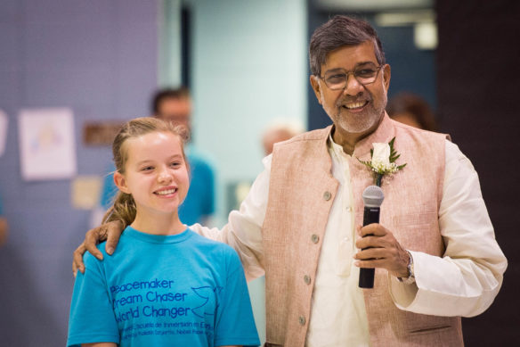 Ada Burris, a 5th grader, stands with Kailash Satyarthi after asking him a question during his visit to the school. Photo by Bobby Ellis, Sept. 23, 2016