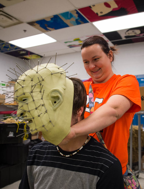 Jodie Carnes, right, helps put a Pinhead mask on the head of Travis Mosley as he gets ready to work at the haunted trail. Bobby Ellis, Oct. 14, 2016
