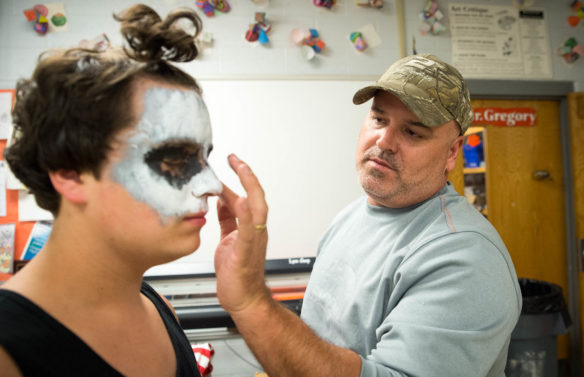 Earl Gregory, right, puts facepaint on his son, Ashton Gregory. Ashton is a freshman who has helped with the haunted trail since it started. "He's been helping out with it for years," said Earl." Photo by Bobby Ellis, Oct. 14, 2016