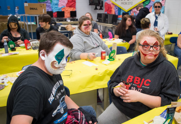 Trent Osborne, left, and Amber Evans put makeup on their face before going to work at the senior classes' haunted trail. Photo by Bobby Ellis, Oct. 14, 2016