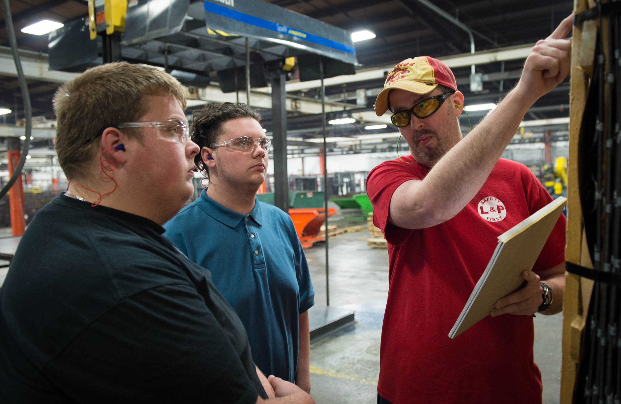 Jeff Fletcher, right, a quality technician at Leggett & Platt's Winchester facility, shows Clark County Area Technology Center students Brett Foley and Garrett Samuels what to look for while doing a quality inspection. Photo by Bobby Ellis, Oct. 25, 2016
