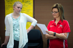Amanda Comstock, right, a teacher at Bullitt East High School (Bullitt County) examines a quiz made by Madisson Kingsley during her business class. Photo by Bobby Ellis; Nov. 1, 2016