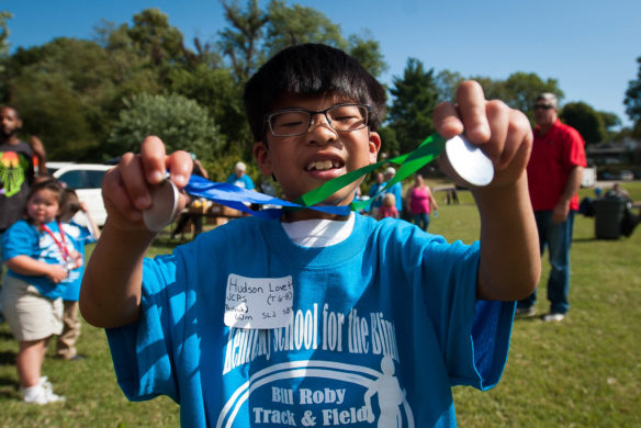 Hudson Lovett, a second grader at Kentucky School for the Blind, holds up his medals he won in the 2016 Bill Roby Track and Field Games. Photo by Bobby Ellis; Oct. 12, 2016