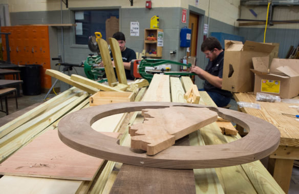 Students at the Breckinridge County Area Technology Center are building a wooden version of the Kentucky Department of Education's logo that will be displayed at the KDE offices in Frankfort. Students such as Nick Stinson, left, are working on the logo under the direction of carpentry instructor Will Farmer. Photo by Bobby Ellis, Dec. 21, 2016