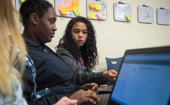 Summer Miller helps Nia Hudson, both freshmen at North Hardin High School, during their "Girls Who Code" class at the Hardin County Early College and Career Center. Hardin County has the only Girls Who Code chapter in Kentucky that is not conducted as a club. Photo by Bobby Ellis, Jan. 30, 2017