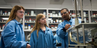 Frances King, left, and Lindsey Highley, center, students George Rogers Clark High School (Clark County), are shown a machine used to test medicine by Pavan Dasari during a tour of a laboratory in which they will be working at Catalent Pharma Solutions in Winchester. The students have been hired through the Youth Employment Solutions (YES!) program, through which students can gain real-world experience at businesses that previously might not have been able to hire them. Photo by Bobby Ellis, Feb. 9, 2017