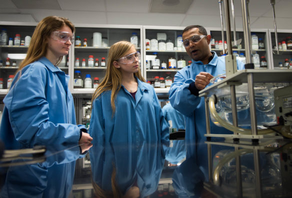 Frances King, left, and Lindsey Highley, center, students George Rogers Clark High School (Clark County), are shown a machine used to test medicine by Pavan Dasari during a tour of a laboratory in which they will be working at Catalent Pharma Solutions in Winchester. The students have been hired through the Youth Employment Solutions (YES!) program, through which students can gain real-world experience at businesses that previously might not have been able to hire them. Photo by Bobby Ellis, Feb. 9, 2017