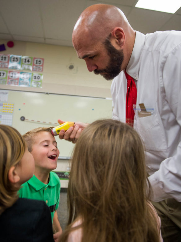 Josh McKeel, principal of Southwest Calloway Elementary (Calloway County), uses the eraser on a toy pencil to "erase" the face of Kase Jones while visiting a kindergarten classroom. McKeel and the staff at Southwest Calloway, a 2016 National Blue Ribbon School, go to great lengths to celebrate student success. Photo by Bobby Ellis, Dec. 8, 2016