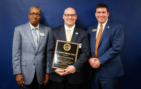 David Martorano, president and chief executive officer of the YMCA of Central Kentucky, receives the Dr. Samuel Robinson Award on behalf of the YMCA from Commissioner of Education Stephen Pruitt, left, and Kentucky Board of Education Chairman William Twyman at the board’s meeting in Frankfort on April 12. Photo by Mike Marsee, April 12, 2017