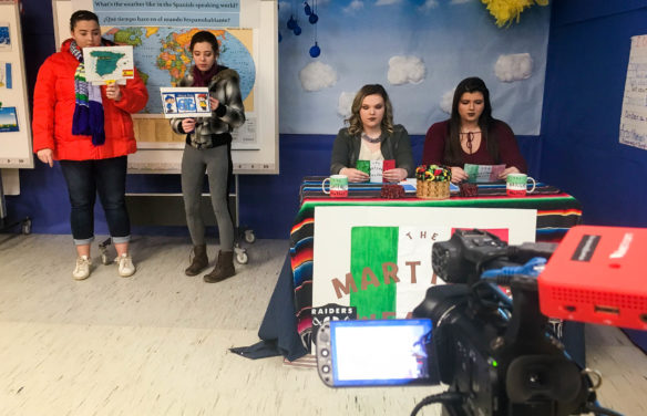 South Floyd High School students Katelyn Hamilton, from left, and Shannon Rogers give a weather forecast for Spain. At the anchor desk, Bailey Addington and Emily Branham prepare to introduce the next forecasters. The Spanish I students wrote the script for the live lesson, which was broadcast on the Grita Fuerte website. Submitted photo