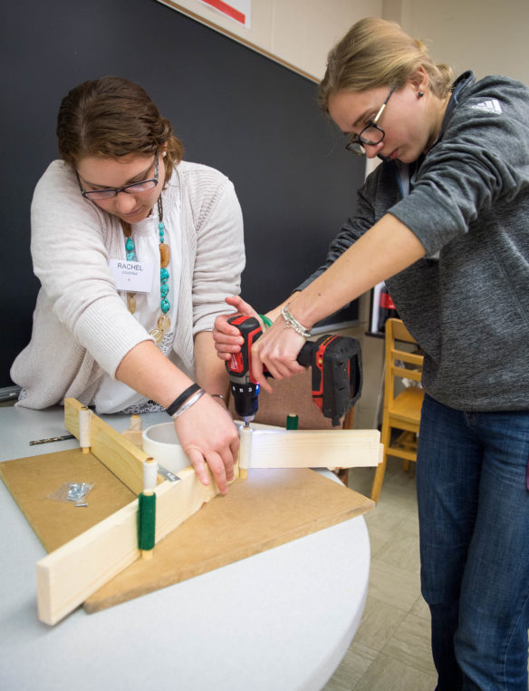 Rachel Newsome, left, a 4th-grade teacher at Caverna Elementary School (Caverna Independent) works with Laryssa Cybriwsky, a 6th- and 8th-grade science teacher at Eminence Middle School (Eminence Independent), to make a base for a telescope at the solar science workshop at Western Kentucky University. Educators made telescopes that will allow groups of students to safely view the Aug. 21 total solar eclipse. Photo by Bobby Ellis, April 7, 2017