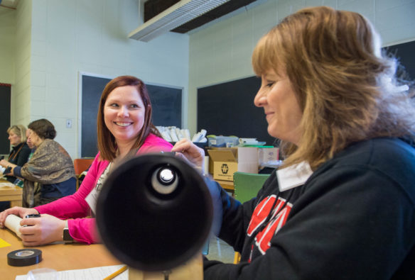 Allison Ramsey, a 4th-grade teacher at Greenville Elementary (Muhlenberg County), left, works with Penny Roberts, an instructional supervisor in the Muhlenberg County schools, to fasten a lens onto Roberts' telescope, during a solar science workshop at Western Kentucky University. Many educators whose schools are in the total eclipse zone are planning activities that will involve their entire school. Photo by Bobby Ellis, April 7, 2017