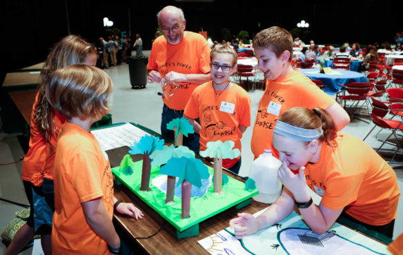 Mike Fairchild, the head custodian at White's Tower Elementary School (Kenton County) and one of the advisers for the school's E-Wise team, laughs with students on the team as they set up their exhibit. The exhibit displayed a model of a wetland on their school's grounds, replicating the way an aerator removes water from a pond there. Photo by Mike Marsee, April 27, 2017