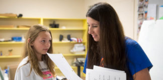 Catherine Knapp, right, an art teacher at Taylorsville Elementary School, reads a note given to her by Savanna Arnold, a 6th-grader, as she cleans her room on the last day of school. Photo by Bobby Ellis, May 23, 2017