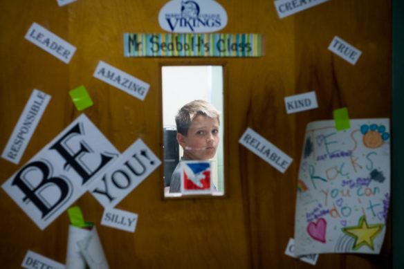 Jackson Coulter, a 4th-grader at Taylorsville Elementary, looks through the door of Joshua Seabolt's classroom. Photo by Bobby Ellis, May 23, 2017