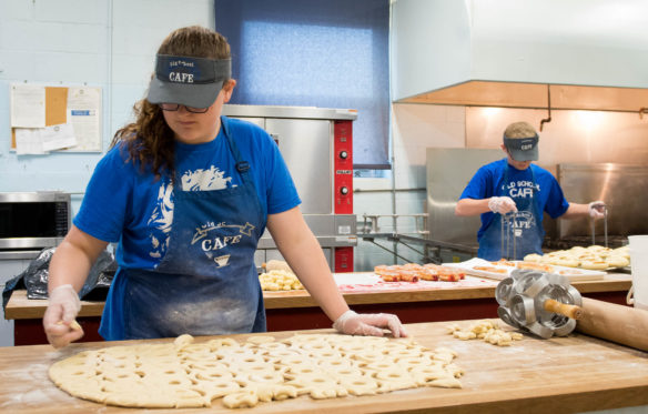 Julie Barlow, a student at Metcalfe County High School, cuts out doughnuts from a roll of dough while working at the Old School Cafe. The cafe's adviser spent six months looking for a recipe for the cinnamon roles and doughnuts sold at the shop. Photo by Bobby Ellis, May 24, 2017