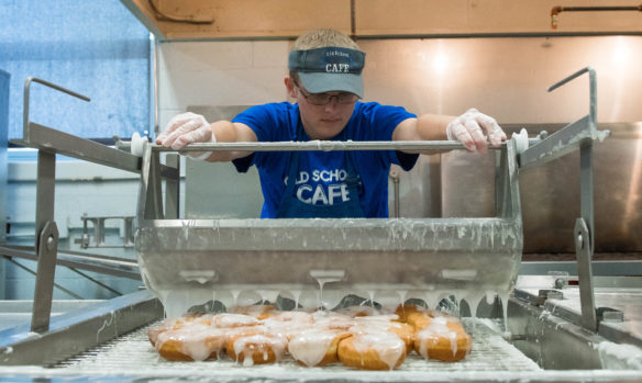 Metcalfe County High School student Taylor Brown glazes cinnamon roles while working at the Old School Cafe. Students can work one morning a week from 4 a.m. to 10 a.m. Photo by Bobby Ellis, May 24, 2017