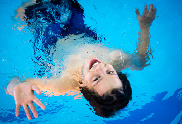 Apollo Tunstall waves to the camera as he floats on his back during an elementary school field day at the pool.<br srcset=