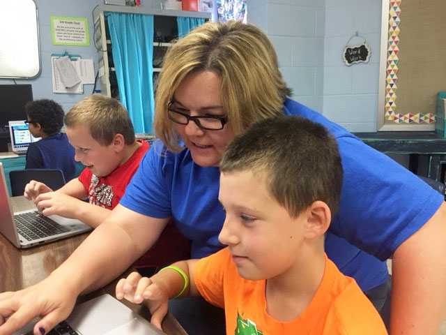 Rene Thompson, a teacher at Caverna Elementary (Caverna Independent), helps a student with a personalized Google Classroom assignment designed to assist the student with mastery of reading skills. Teacher leaders, engaged in a professional learning community through the kid·FRIENDLy Communities of Practice, developed classrooms that are models of personalized learning. (Photo submitted)