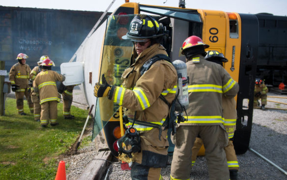 Woodford County firefighters pull out the windshield of the tipped over bus to make it easier to reach those inside.<br srcset=