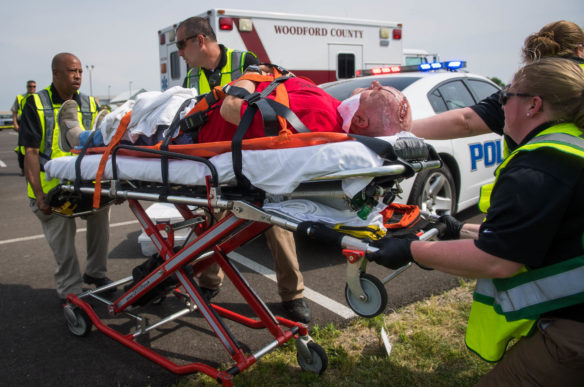 Medical personnel use a gurney to take the injured bus driver to an ambulance. Volunteers playing severely injured or dead passengers were not allowed to speak and some were transported to a makeshift triage area.<br srcset=