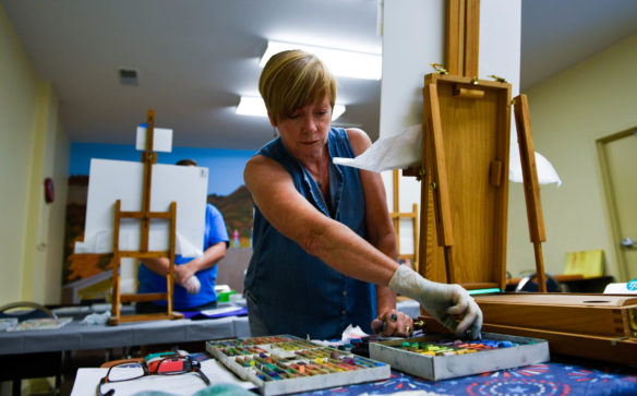 Diana Colgate, an instructor at the Berea Festival of Learnshops, searches through pastel chalk for the right color during her landscape pastel in a day class. Photo by Bobby Ellis, July 11, 2017