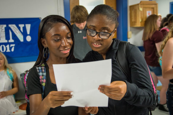 Zoei Ferrell, left, and Zaria Ferrell, 10th-graders at Frankfort High School (Frankfort Independent) look over their schedules before the start of classes on the first day of school.  Photo by Bobby Ellis, Aug. 1, 2017