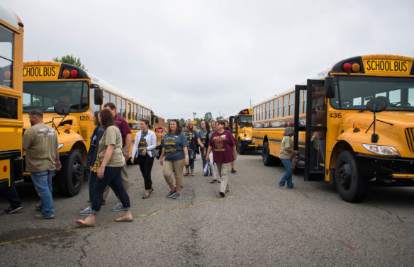 Teachers and staff from Webster County Schools load onto buses to go meet students during a back to school event on opening day.  Photo by Bobby Ellis, Aug. 7, 2017
