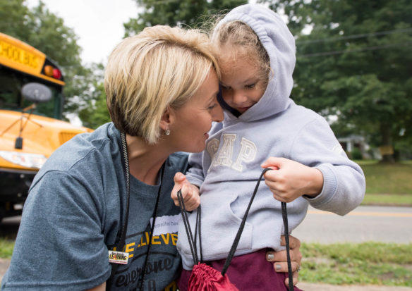 Jennifer David, a 1st-grade teacher at Providence Elementary (Webster County) hugs Blissful Armstrong after giving her a backpack during a home visit on the opening day of schools. Teachers and staff of Webster County Schools made home visits to high risk students to welcome them back to school.  Photo by Bobby Ellis, Aug. 7, 2017