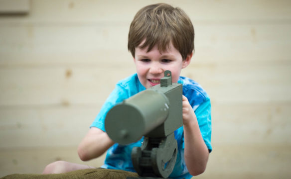 Andrew Mann, of Winchester, plays with a toy machine gun at the World War I Centennial display. Photo by Bobby Ellis, Aug. 24, 2017