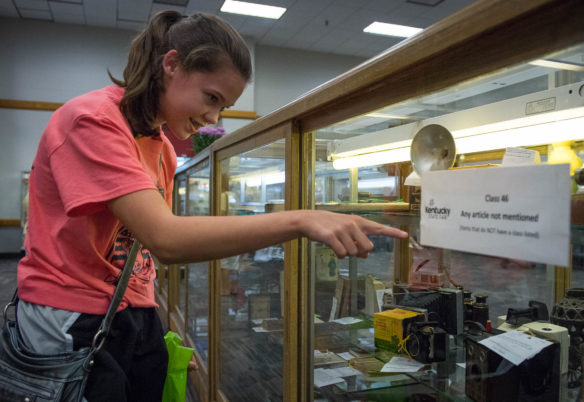 Maria Wilkerson, a student at Taylor County High School, looks at antique camera on display in the Expo Center at the Kentucky State Fair. Photo by Bobby Ellis, Aug. 24, 2017