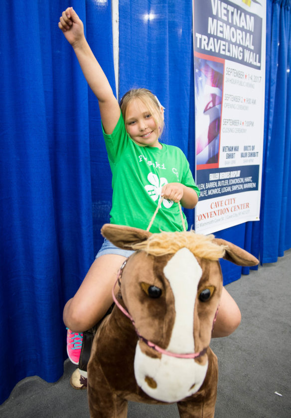 Kaylee Corder, a student at Northern Middle School (Pulaski County) rides a stuffed horse in the south wing of the Expo Center at the Kentucky State Fair.  Photo by Bobby Ellis, Aug. 24, 2017