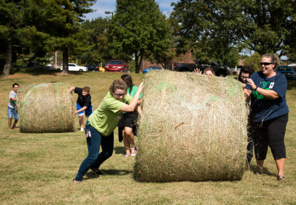 Kentucky School for the Deaf students and staff compete in a hay bale rolling race during the Sweet Corn Festival. Photo by Bobby Ellis, Oct. 6, 2017