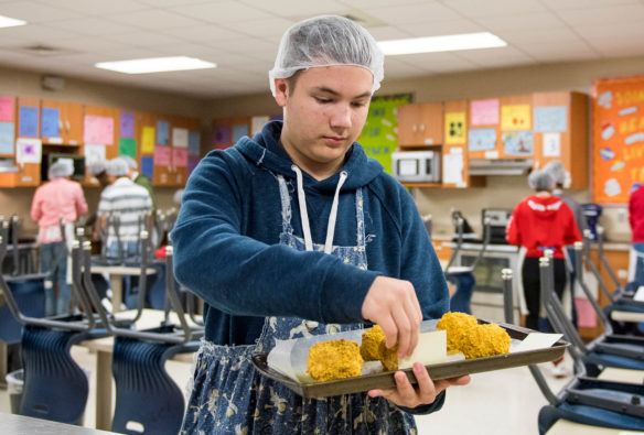 David Barnett, an 11th-grade student at Washington County High School, carries ice cream balls covered in corn flakes to the freezer during Sarah Raikes' foods class. The family and consumer sciences department at Washington County High includes a dozen courses and three career pathways. The school also has the largest Family, Career and Consumer Leaders of America chapter in Kentucky. Photo by Bobby Ellis, Oct. 17, 2017